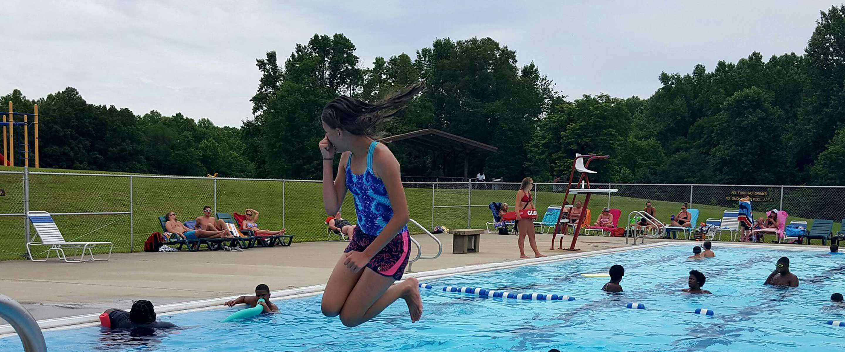girl jumping into pool