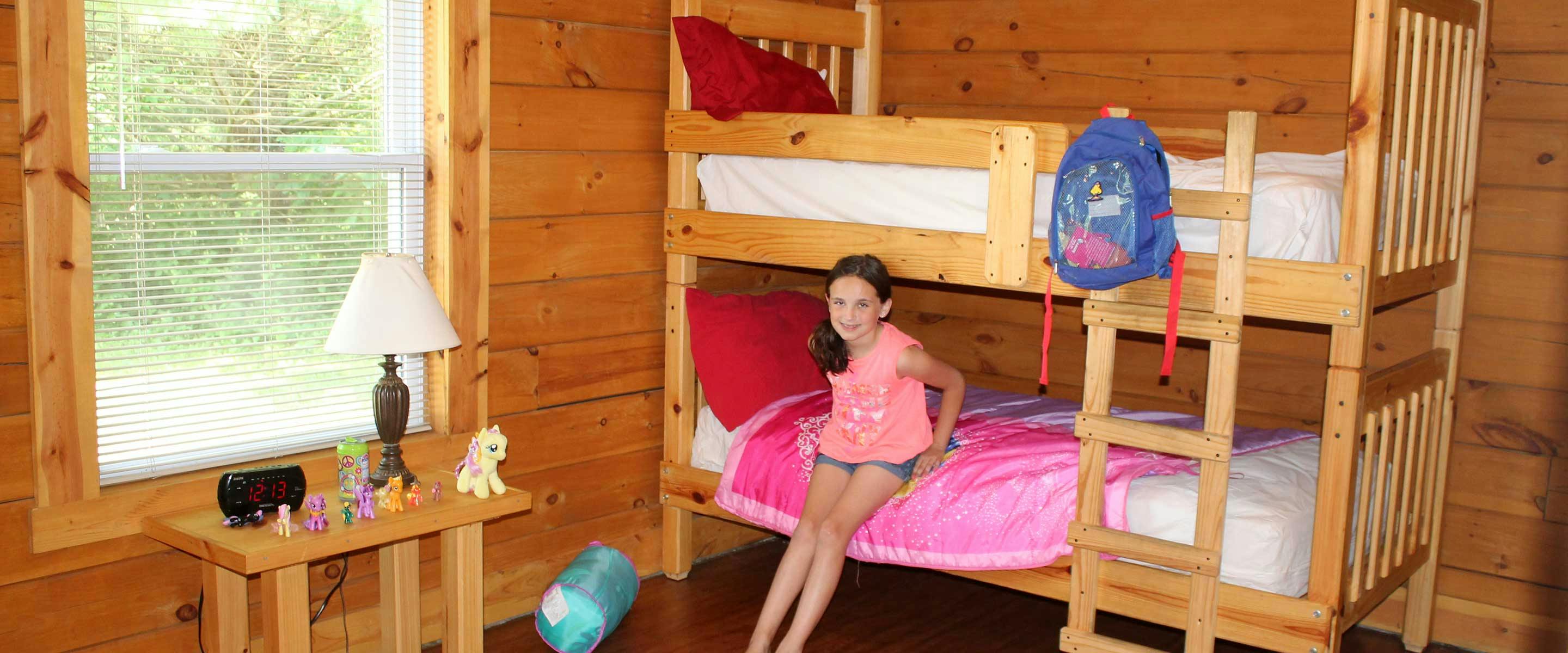 girl leading against bunk bed in cabin