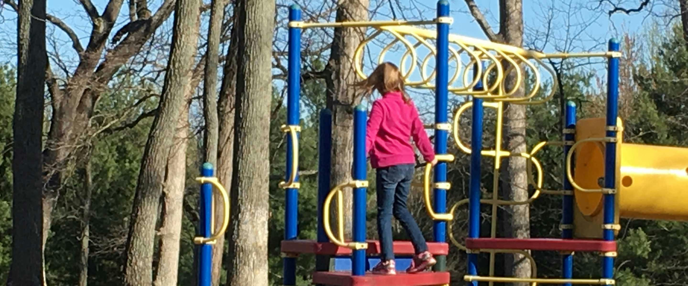 girl playing on nearby playfround equipment