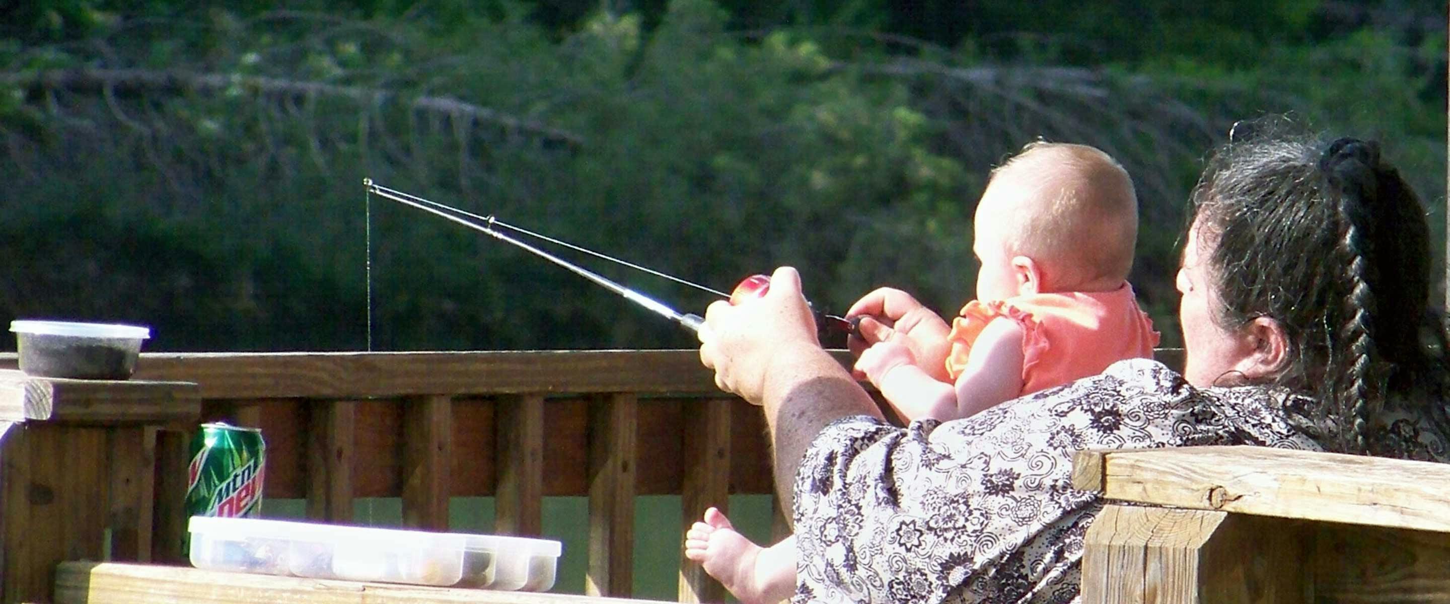 man fishing with baby in his lap