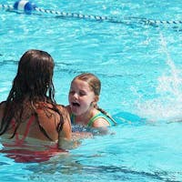 girl lifeguard assisting during swimming lesson